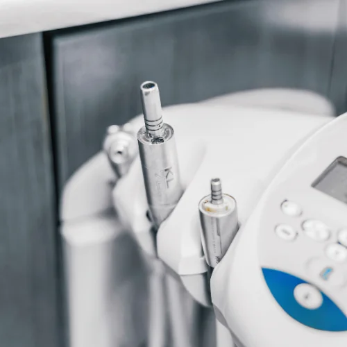 close up view of stainless steel dental handpieces stored on treatment unit tray