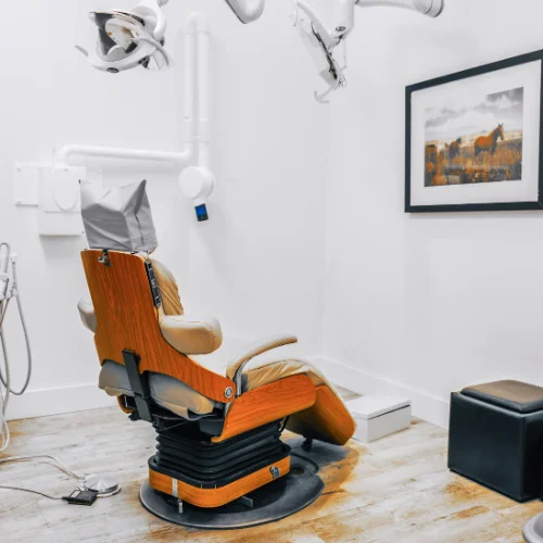 modern dental examination chair with wood finish trim and overhead light setup at shin dentistry